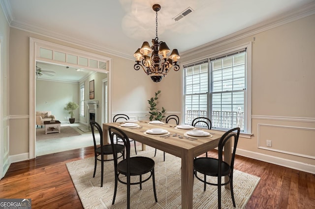 7155 Roswell Rd Unit 58, Atlanta, GA 30328 - dining space featuring a chandelier, a fireplace, ornamental molding, wood finished floors, and a wainscoted wall