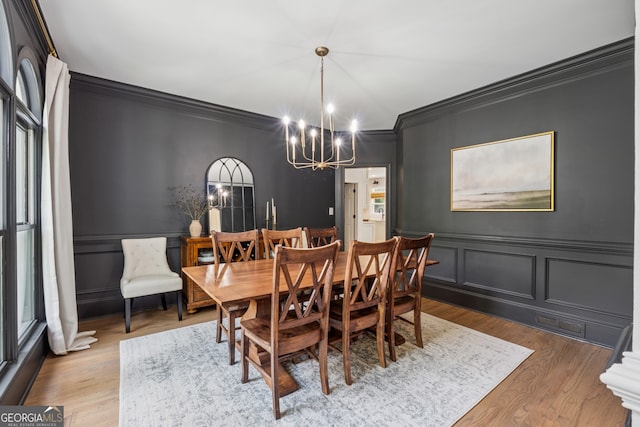 712 Brookshade Pkwy, Alpharetta, GA 30004 - dining area featuring crown molding, a chandelier, a decorative wall, wood finished floors, and wainscoting