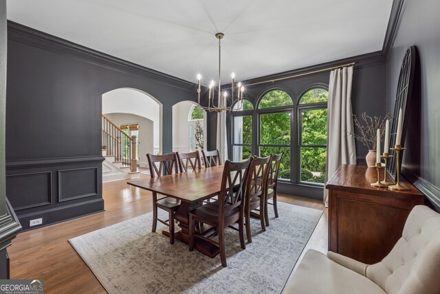 712 Brookshade Pkwy, Alpharetta, GA 30004 - dining space with arched walkways, ornamental molding, a chandelier, stairs, and a decorative wall