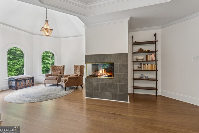712 Brookshade Pkwy, Alpharetta, GA 30004 - sitting room featuring wood finished floors, crown molding, a tiled fireplace, and a chandelier