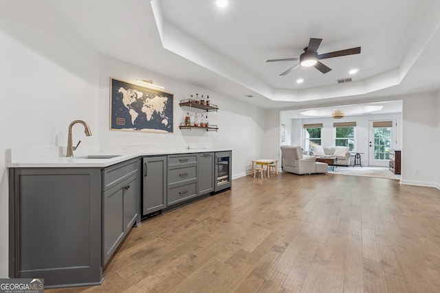 712 Brookshade Pkwy, Alpharetta, GA 30004 - indoor bar featuring a tray ceiling, wine cooler, ceiling fan, light wood-style flooring, and recessed lighting