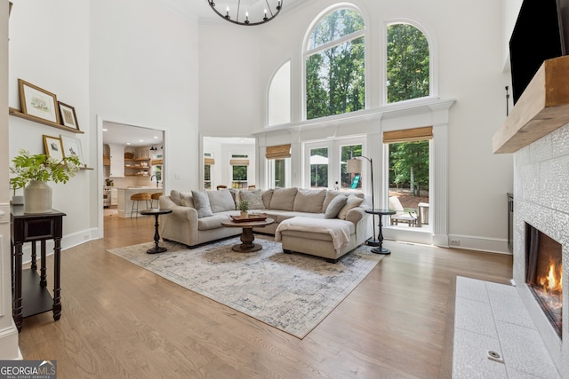 712 Brookshade Pkwy, Alpharetta, GA 30004 - living area with a fireplace, a towering ceiling, baseboards, wood finished floors, and ornamental molding