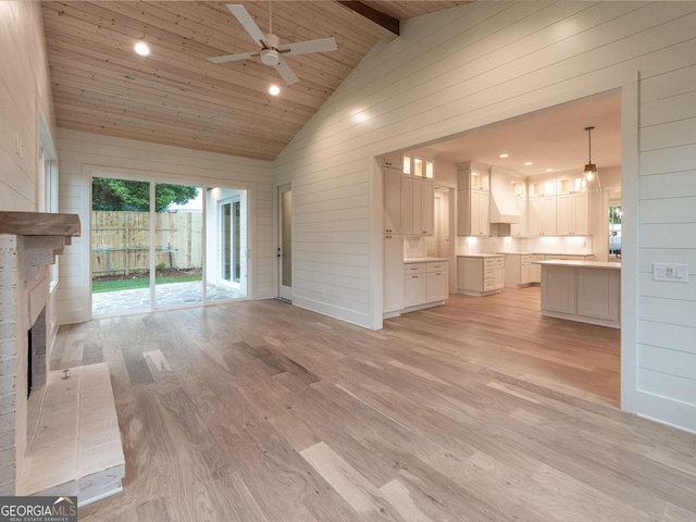 4955 Chamblee Dunwoody Rd, Dunwoody, GA 30338 - unfurnished living room with wooden walls, ceiling fan, light wood-style floors, high vaulted ceiling, and a brick fireplace