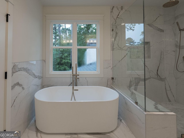 4955 Chamblee Dunwoody Rd, Dunwoody, GA 30338 - bathroom featuring marble look tiles, healthy amount of natural light, tile walls, a freestanding tub, and a wainscoted wall