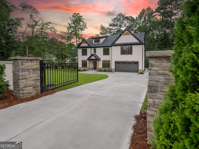 4955 Chamblee Dunwoody Rd, Dunwoody, GA 30338 - view of front facade with an attached garage, driveway, stucco siding, and a gate