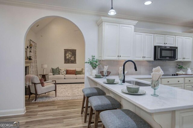 1488 Pleasant Hill Rd NE, Ranger, GA 30734 - kitchen featuring black microwave, arched walkways, backsplash, a kitchen breakfast bar, and a sink
