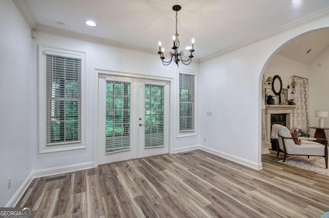 1488 Pleasant Hill Rd NE, Ranger, GA 30734 - unfurnished dining area with french doors, wood finished floors, a chandelier, a glass covered fireplace, and arched walkways