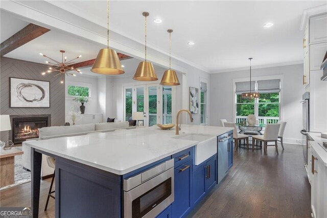 2602 Drew Valley Rd NE, Brookhaven, GA 30319 - kitchen with appliances with stainless steel finishes, blue cabinets, a large fireplace, white cabinets, and recessed lighting