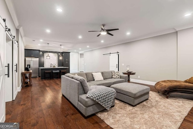 2377 Kesgrove Way, Buford, GA 30518 - living area with a barn door, a ceiling fan, recessed lighting, dark wood-style floors, and ornamental molding