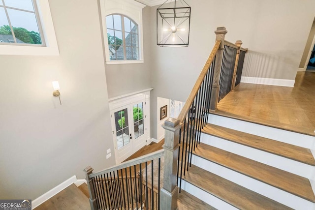 2377 Kesgrove Way, Buford, GA 30518 - stairway featuring a chandelier, wood finished floors, and a towering ceiling