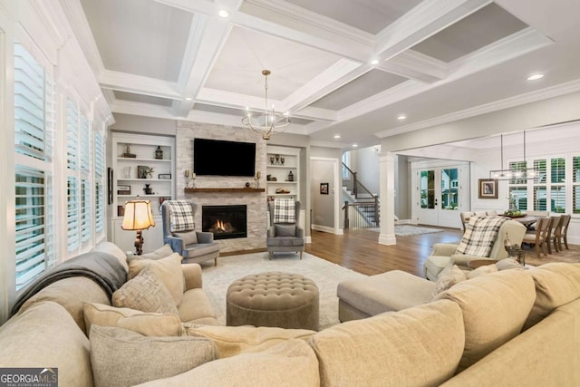 2377 Kesgrove Way, Buford, GA 30518 - living area with wood finished floors, a chandelier, a fireplace, stairs, and ornamental molding