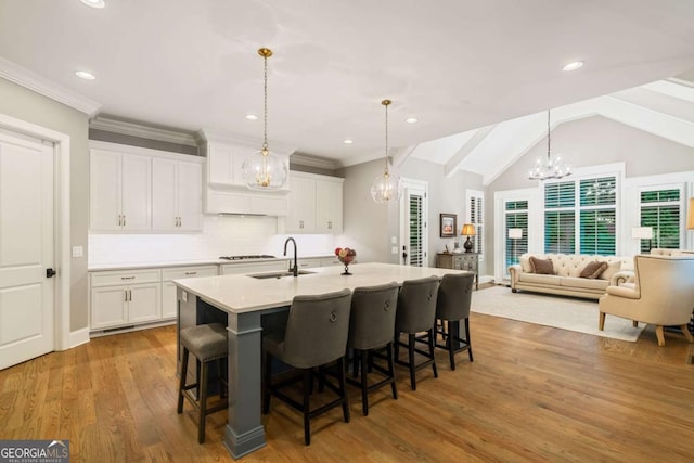 2377 Kesgrove Way, Buford, GA 30518 - kitchen featuring a chandelier, white cabinetry, a breakfast bar area, light countertops, and light wood-style floors