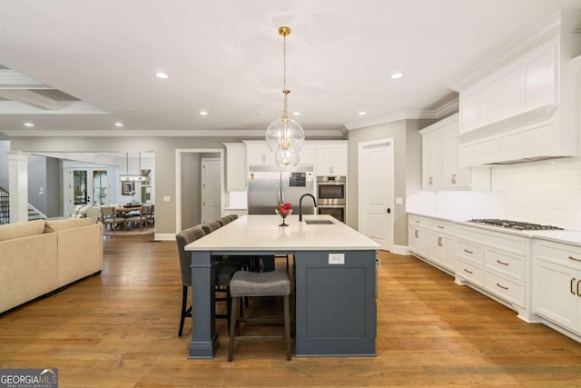 2377 Kesgrove Way, Buford, GA 30518 - kitchen featuring appliances with stainless steel finishes, white cabinetry, open floor plan, decorative backsplash, and a breakfast bar