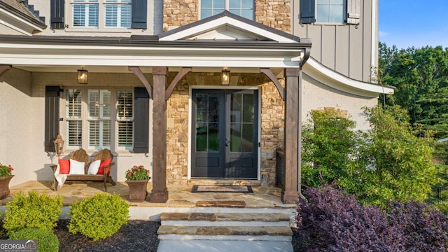 2377 Kesgrove Way, Buford, GA 30518 - doorway to property featuring stone siding, board and batten siding, french doors, and covered porch