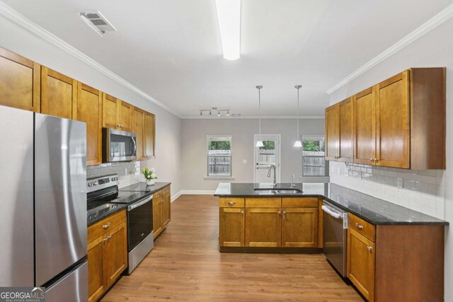 4546 Water Mill Dr, Buford, GA 30519 - kitchen with appliances with stainless steel finishes, a peninsula, brown cabinets, light wood-style flooring, and backsplash