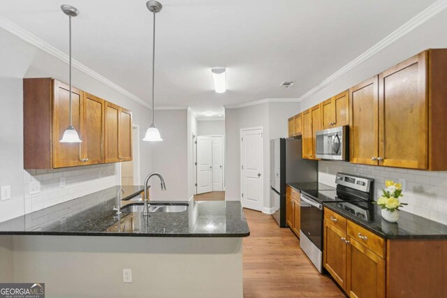 4546 Water Mill Dr, Buford, GA 30519 - kitchen with appliances with stainless steel finishes, light wood-style flooring, a peninsula, backsplash, and crown molding