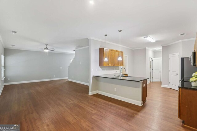 4546 Water Mill Dr, Buford, GA 30519 - kitchen with dark countertops, ceiling fan, dark wood-style flooring, ornamental molding, and a peninsula
