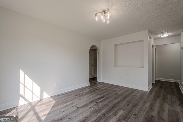 2576 Abbotts Glen Dr NW, Acworth, GA 30101 - empty room featuring arched walkways, dark wood-type flooring, baseboards, and a textured ceiling