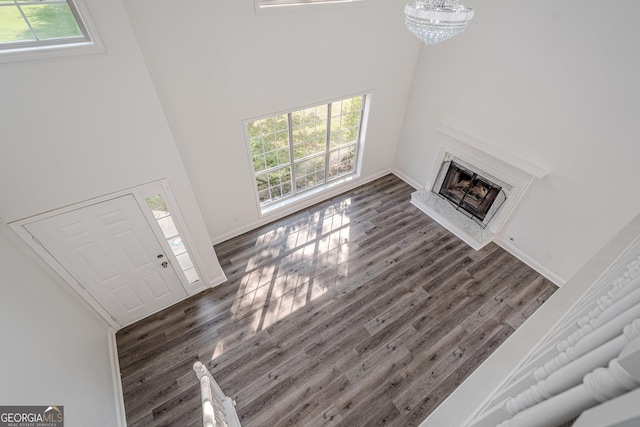 2576 Abbotts Glen Dr NW, Acworth, GA 30101 - unfurnished living room featuring a towering ceiling, wood finished floors, a high end fireplace, baseboards, and a chandelier