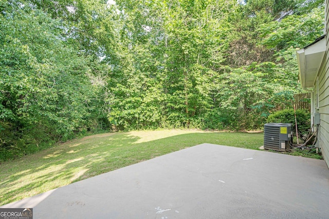 2576 Abbotts Glen Dr NW, Acworth, GA 30101 - view of grassy yard with a patio area, central air condition unit, and a wooded view