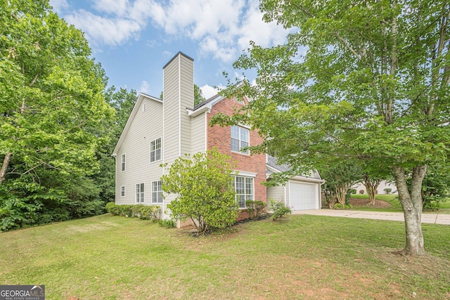 2576 Abbotts Glen Dr NW, Acworth, GA 30101 - view of side of home with concrete driveway, a yard, an attached garage, brick siding, and a chimney