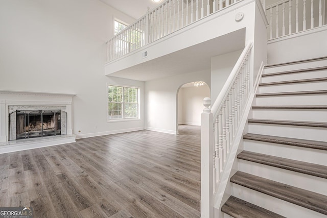 2576 Abbotts Glen Dr NW, Acworth, GA 30101 - unfurnished living room with arched walkways, wood finished floors, baseboards, stairs, and a fireplace