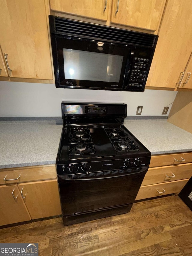 320 Martin Luther King Jr Dr SE Unit 5, Atlanta, GA 30312 - kitchen with black appliances, wood finished floors, and light countertops