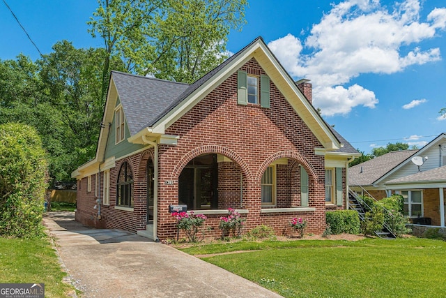 1391 Jefferson Ave, East Point, GA 30344 - view of front of property with brick siding, a chimney, a front yard, roof with shingles, and covered porch