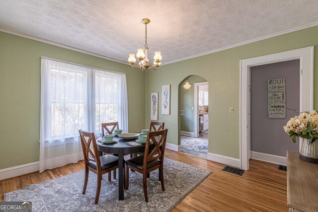 1391 Jefferson Ave, East Point, GA 30344 - dining room with arched walkways, ornamental molding, healthy amount of natural light, a textured ceiling, and a chandelier