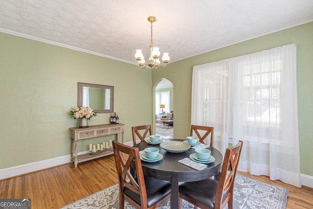 1391 Jefferson Ave, East Point, GA 30344 - dining area with arched walkways, light wood-style floors, baseboards, a chandelier, and crown molding