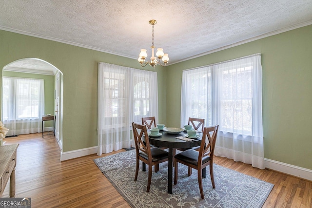 1391 Jefferson Ave, East Point, GA 30344 - dining room featuring arched walkways, a chandelier, baseboards, a textured ceiling, and ornamental molding