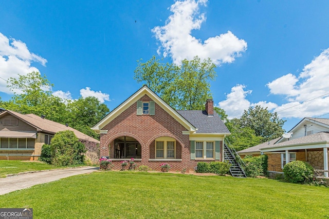 1391 Jefferson Ave, East Point, GA 30344 - traditional-style home with brick siding, a chimney, a front lawn, and stairway