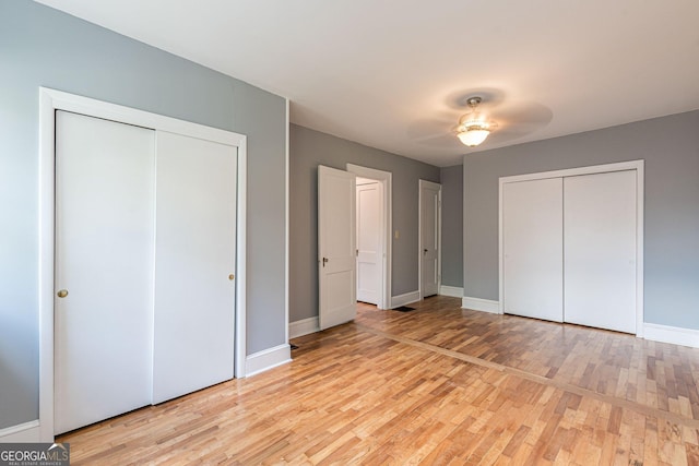 1391 Jefferson Ave, East Point, GA 30344 - unfurnished bedroom with light wood finished floors, baseboards, two closets, and ceiling fan