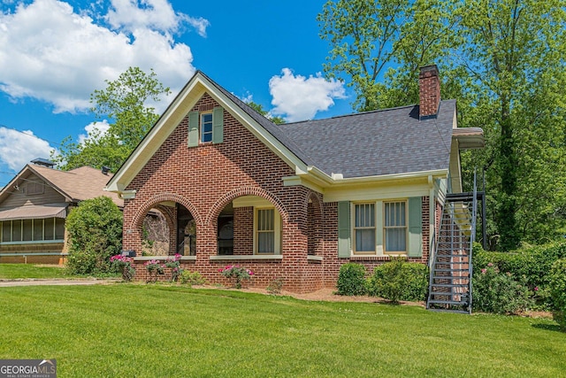 1391 Jefferson Ave, East Point, GA 30344 - view of front of house with brick siding, a front yard, a chimney, roof with shingles, and stairs