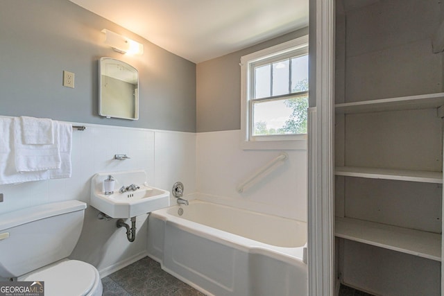 1391 Jefferson Ave, East Point, GA 30344 - full bathroom featuring toilet, a garden tub, a wainscoted wall, tile walls, and a sink
