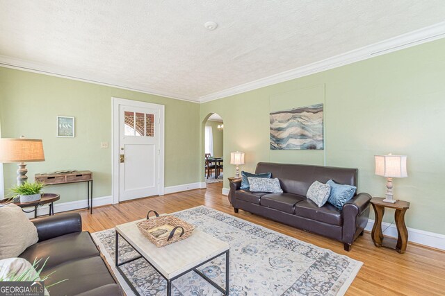 1391 Jefferson Ave, East Point, GA 30344 - living area with arched walkways, ornamental molding, light wood-style floors, a textured ceiling, and baseboards