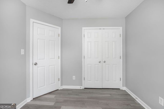 6947 Gallant Cir Unit 10, Mableton, GA 30126 - unfurnished bedroom featuring wood finished floors, a closet, baseboards, a ceiling fan, and a textured ceiling