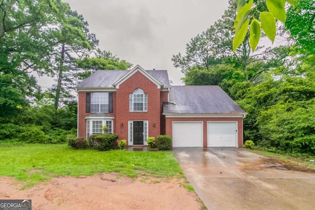 2191 Phillips Rd, Lithonia, GA 30058 - colonial house with an attached garage, concrete driveway, a front yard, brick siding, and roof with shingles