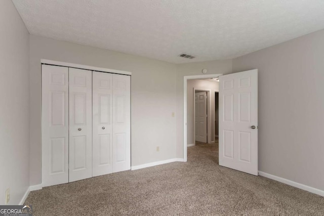 2191 Phillips Rd, Lithonia, GA 30058 - unfurnished bedroom with carpet, baseboards, a closet, and a textured ceiling