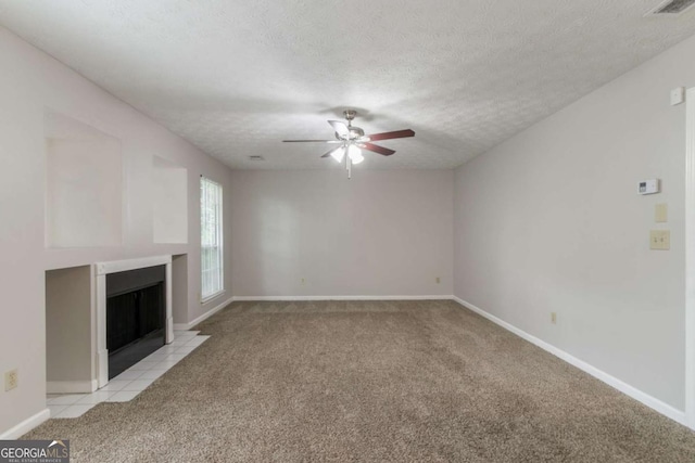2191 Phillips Rd, Lithonia, GA 30058 - unfurnished living room with light carpet, a ceiling fan, a textured ceiling, a fireplace with flush hearth, and baseboards