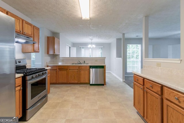 2191 Phillips Rd, Lithonia, GA 30058 - kitchen featuring appliances with stainless steel finishes, under cabinet range hood, a peninsula, a sink, and light countertops