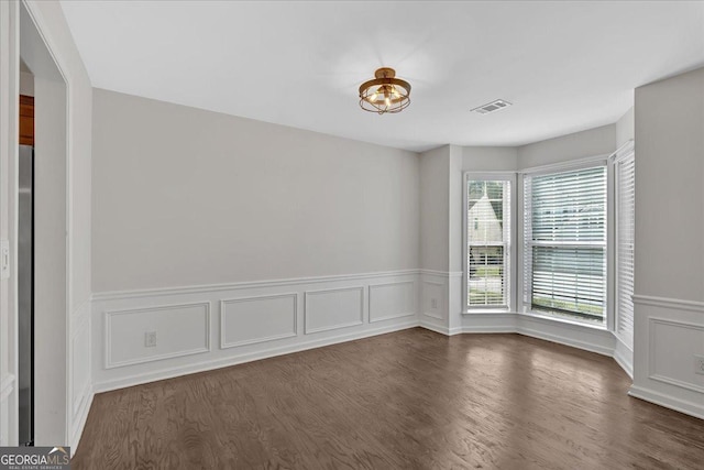 535 Watercress Dr, Woodstock, GA 30188 - spare room with dark wood-style floors, a wainscoted wall, and a decorative wall
