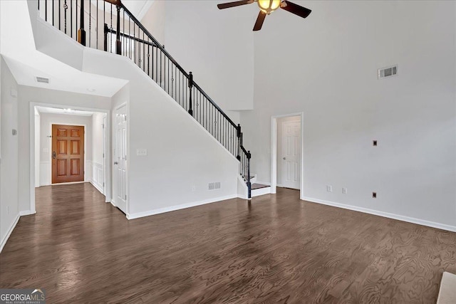 535 Watercress Dr, Woodstock, GA 30188 - unfurnished living room featuring ceiling fan, a high ceiling, dark wood-style floors, stairway, and baseboards