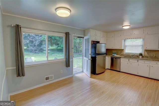 2808 Peeler Rd, Dunwoody, GA 30360 - kitchen featuring stainless steel appliances, white cabinetry, a sink, and light wood-style floors
