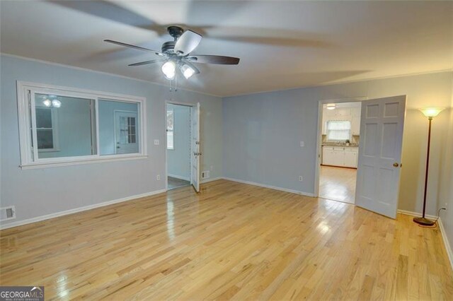 2808 Peeler Rd, Dunwoody, GA 30360 - spare room featuring ceiling fan, light wood-type flooring, baseboards, healthy amount of natural light, and crown molding