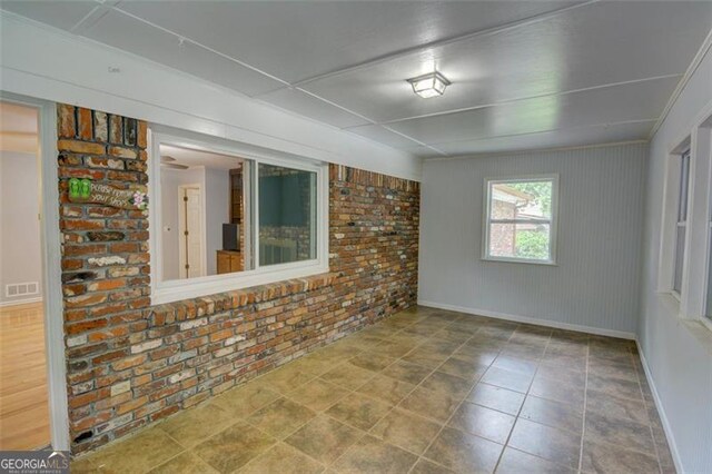 2808 Peeler Rd, Dunwoody, GA 30360 - unfurnished room with brick wall and baseboards