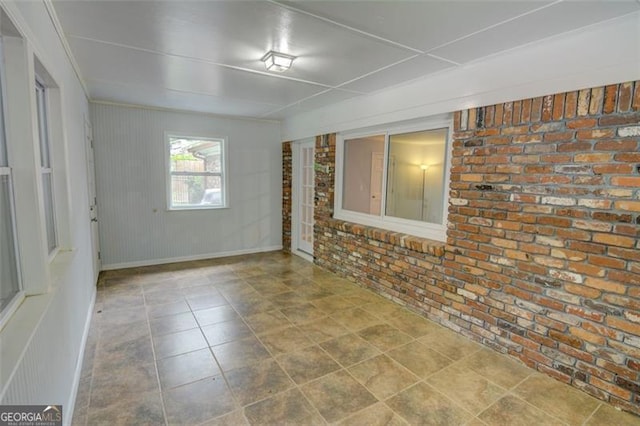 2808 Peeler Rd, Dunwoody, GA 30360 - tiled empty room with brick wall and baseboards