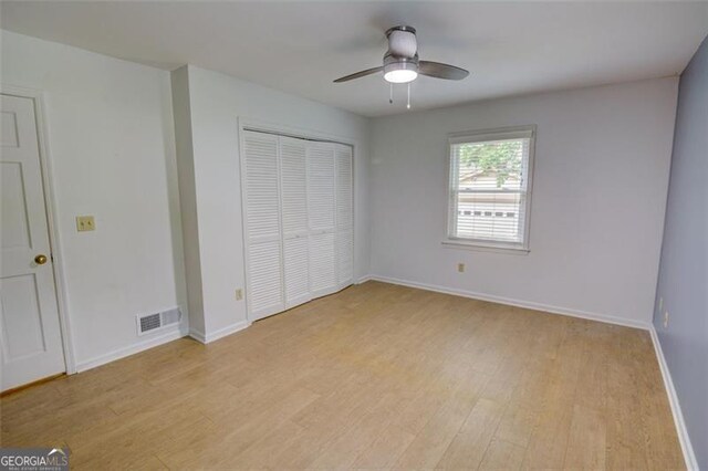 2808 Peeler Rd, Dunwoody, GA 30360 - unfurnished bedroom with light wood-style floors, a closet, baseboards, and ceiling fan