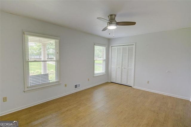 2808 Peeler Rd, Dunwoody, GA 30360 - unfurnished bedroom with light wood finished floors, baseboards, a closet, and ceiling fan