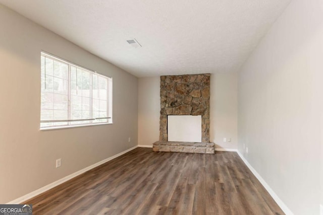 5092 Stone Trce, Stone Mountain, GA 30083 - unfurnished living room with wood finished floors, a stone fireplace, and baseboards